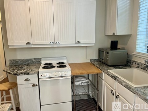 A kitchen with white cabinets and a granite countertop.