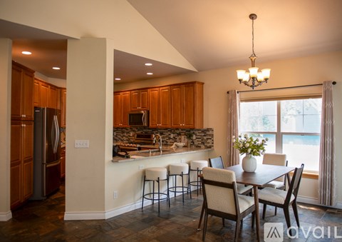 A kitchen with a dining table and chairs.