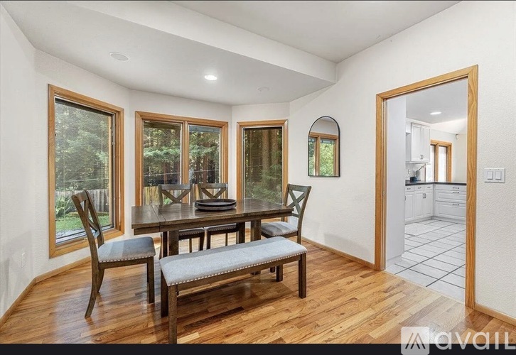 A dining room with a wooden table and chairs.