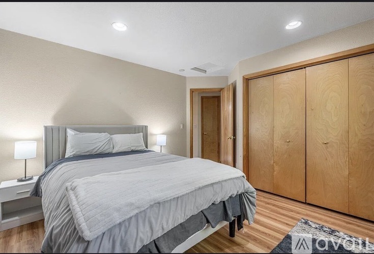 A bedroom with a large bed and wooden wardrobes.