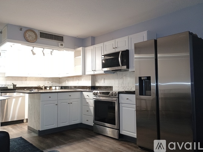 A modern kitchen with stainless steel appliances and white cabinets.