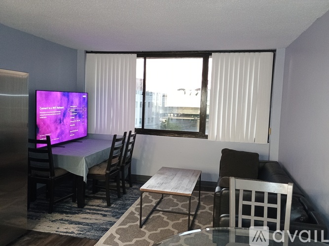 A living room with a television, chairs, and a table.