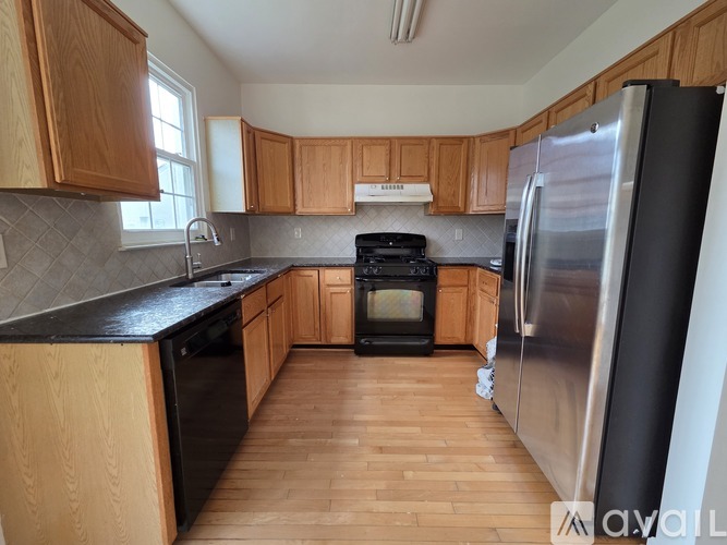 A kitchen with wooden cabinets and a black countertop.
