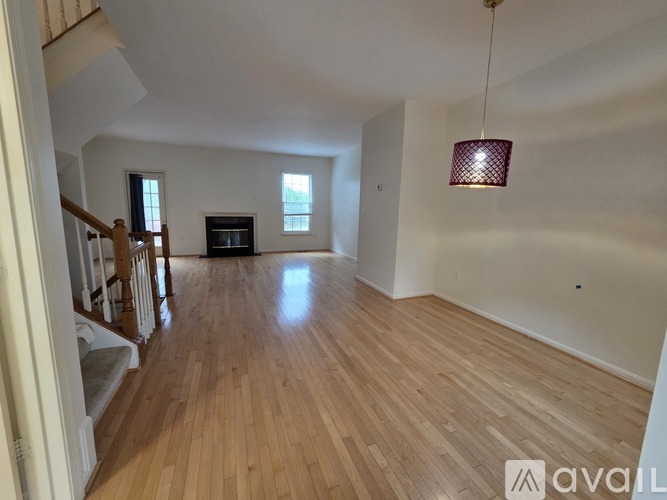 A room with wooden flooring and a hanging lamp.