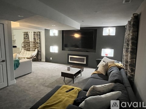 A living room with a grey couch and a television.