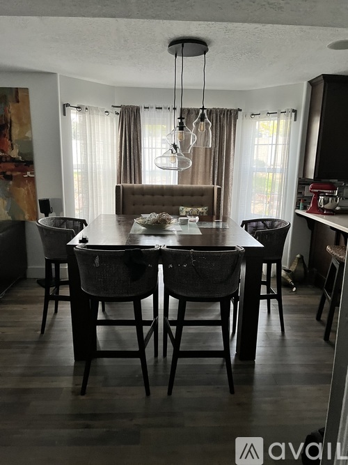 A dining room with a wooden table and chairs.