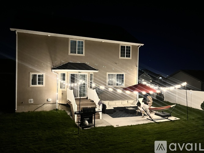 A house with a patio and a hot tub is lit up at night.