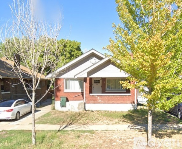 A small house with a white car parked in front.