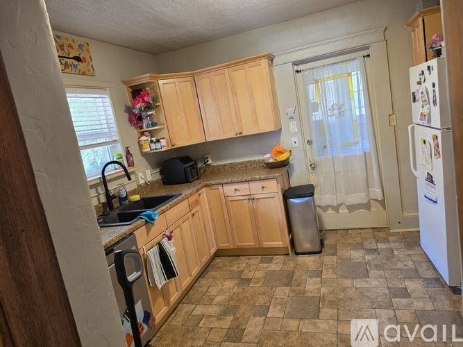 A kitchen with wooden cabinets and a tiled floor.