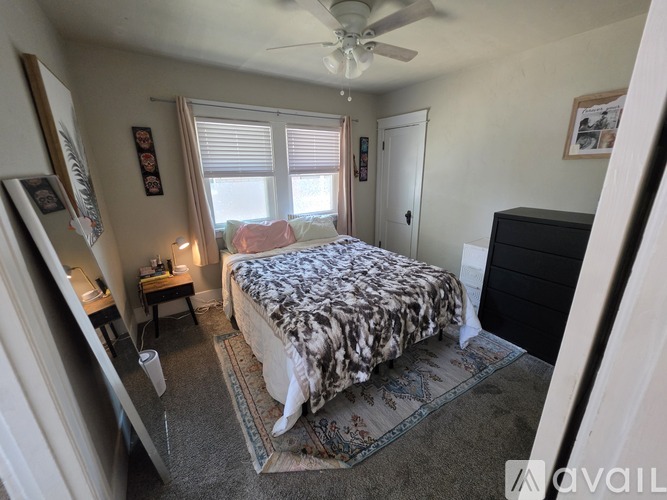 A bedroom with a bed, dresser, and window.