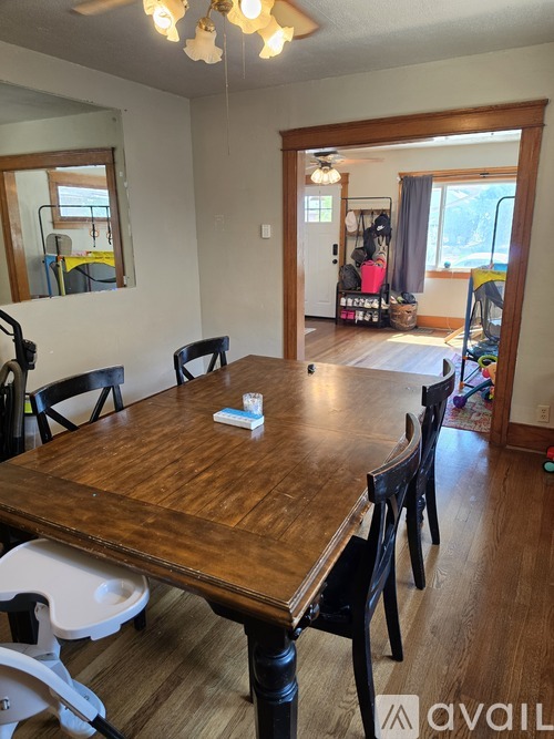 A dining room with a wooden table and chairs.
