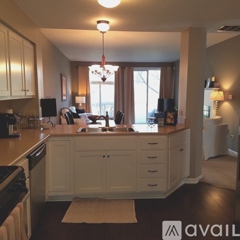 A kitchen with white cabinets and a brown rug on the floor.