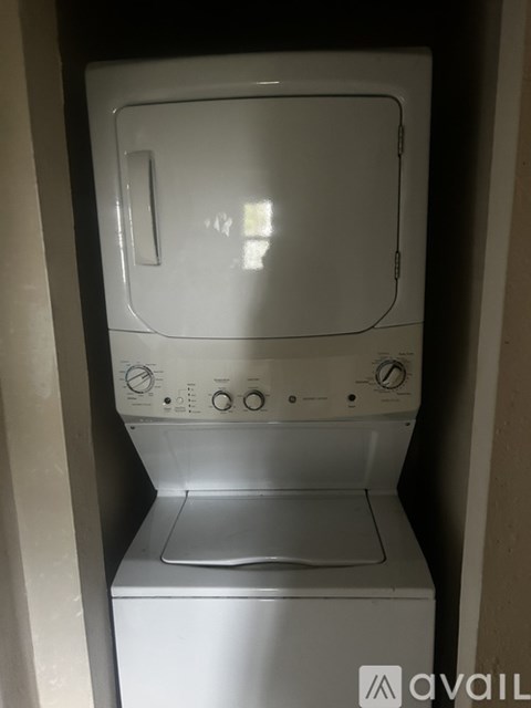 A white washing machine is sitting in a small space.