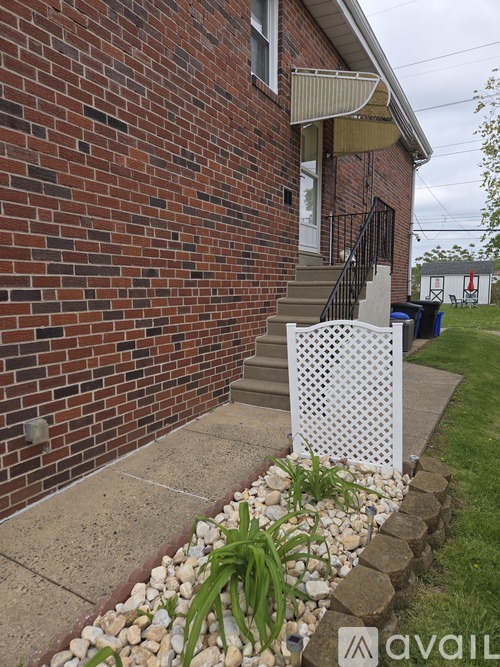A red brick house with a white lattice fence.