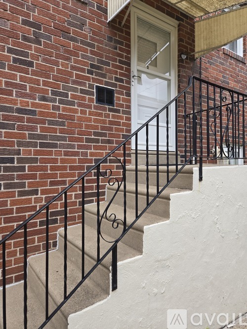 A staircase with a black railing leads to a white door.