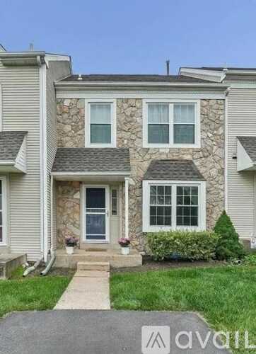 A house with a stone facade and a grey roof.