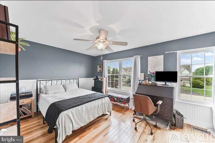 A bedroom with two beds and a desk with a chair.