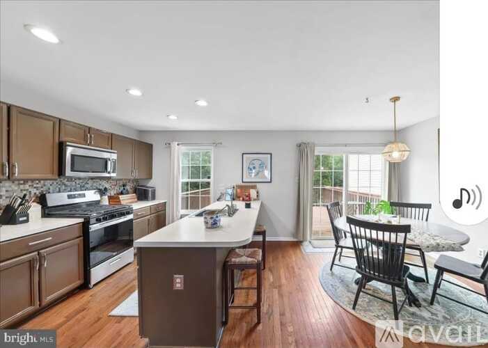 A kitchen with wooden cabinets and a white island.