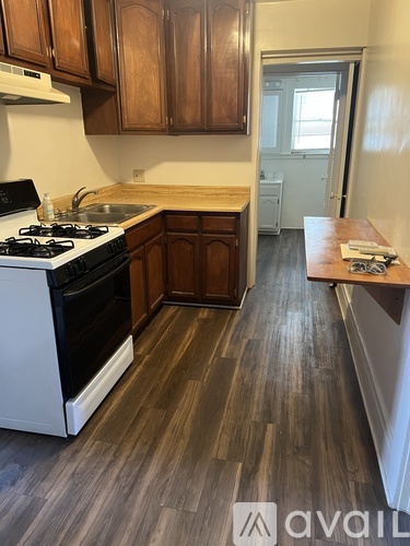 A kitchen with wooden cabinets and a white stove top oven.