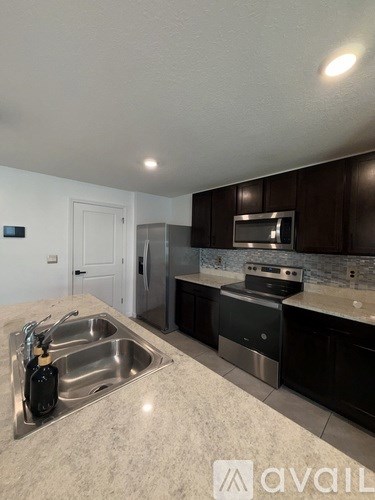 A kitchen with a sink and a microwave.