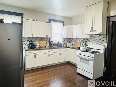 A kitchen with white cabinets and a stove top oven.