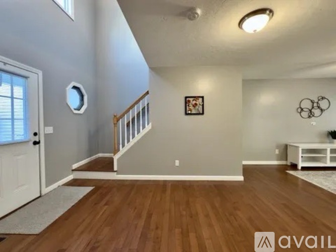 A living room with a white couch and a painting on the wall.