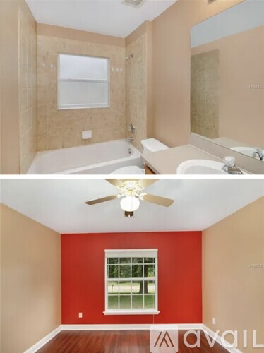 A bathroom with a red wall and a ceiling fan.