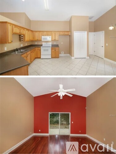 A kitchen with wooden cabinets and a white fridge, and a room with red walls and a white ceiling fan.