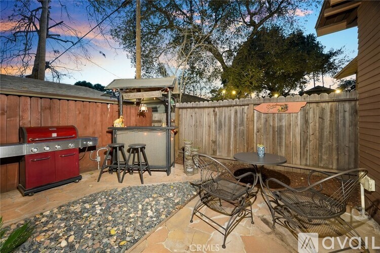 A backyard with a BBQ grill and patio furniture.