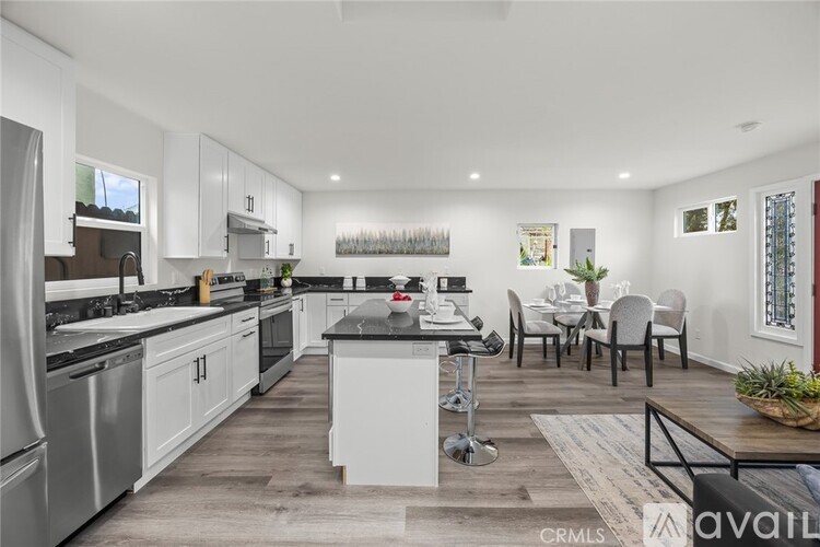 A modern kitchen with white cabinets and stainless steel appliances.
