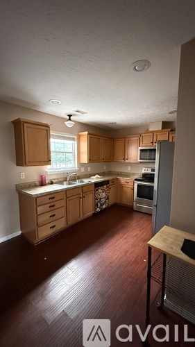 A kitchen with wooden cabinets and a refrigerator.