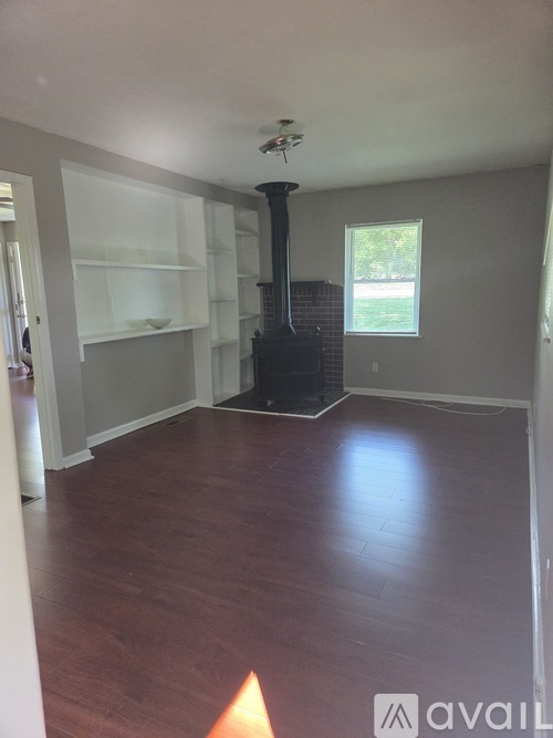 A living room with wood floors and a fireplace.