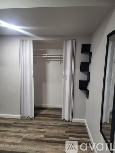 A room with a wooden floor and white walls.