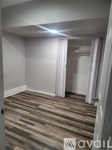 A room with wooden flooring and a white door.