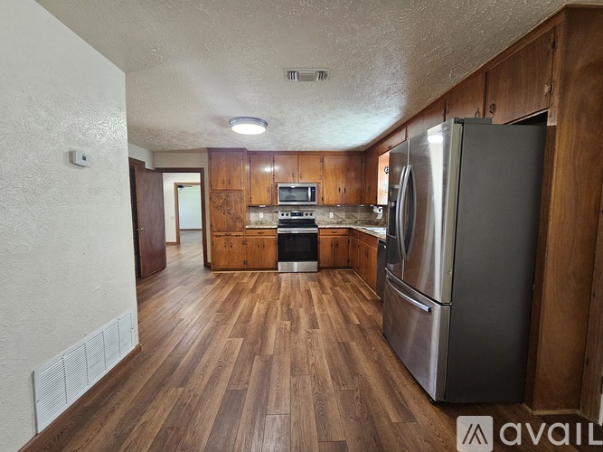 A kitchen with wooden cabinets and a refrigerator.