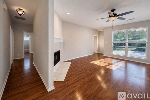 A spacious living room with hardwood floors and a ceiling fan.