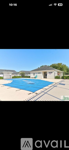 A large house with a blue pool in front.