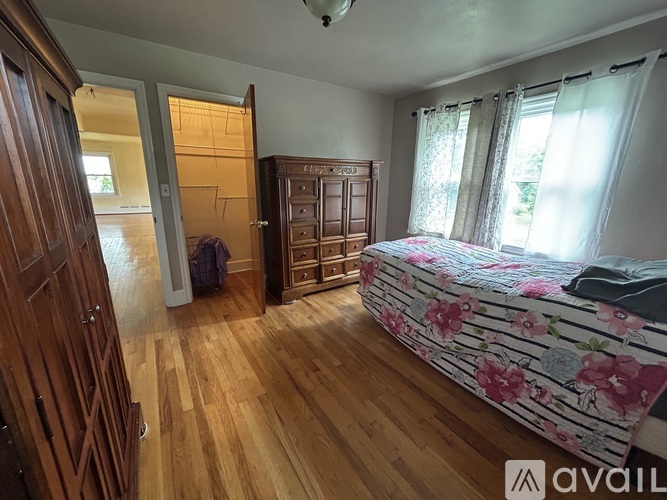 A bedroom with a bed, wardrobe, and wooden floors.
