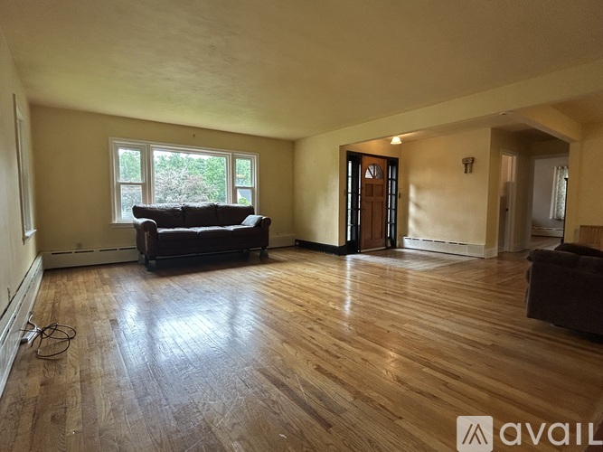 A living room with a brown couch and a wooden floor.