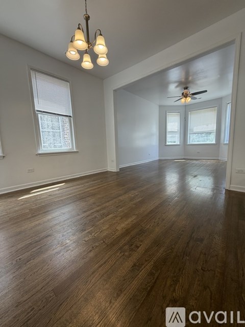 A room with wooden floors and a ceiling fan.
