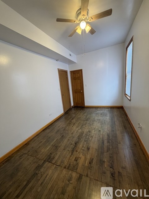 A room with wooden flooring and a ceiling fan.