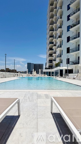 A pool in front of a tall white building.