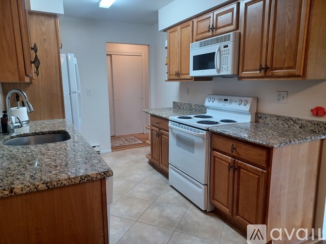 A kitchen with granite countertops and white appliances.