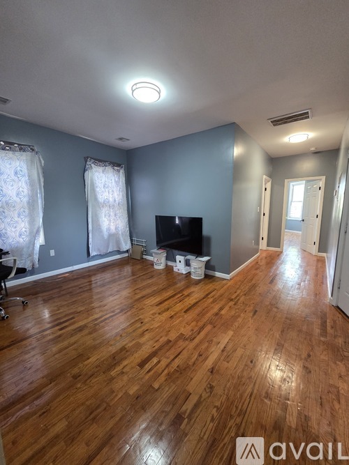 A room with wooden floors and a television set.