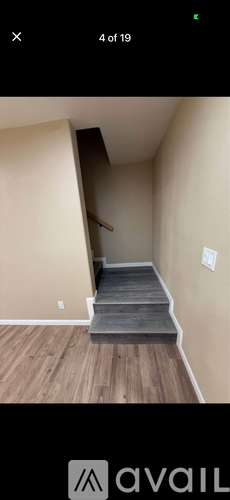 A staircase with wooden steps and a beige wall.