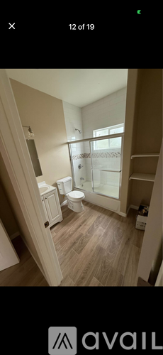 A bathroom with a toilet, sink, and mirror.
