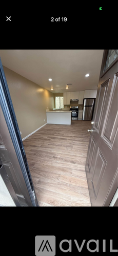 A modern kitchen with wooden flooring and a large island.