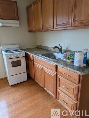 A kitchen with wooden cabinets and a white stove.