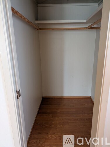 A small, empty room with wooden floors and white walls.