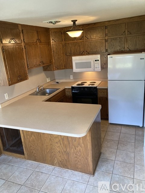 A kitchen with wooden cabinets and a white refrigerator.